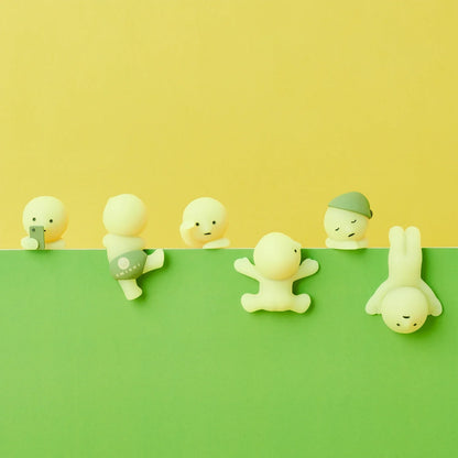 Set of toy figures on a green and yellow background