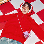 Person wearing a red hoodie with a checkered floor background