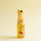 Spray Bottle with Winnie the Pooh design on a table with gradient