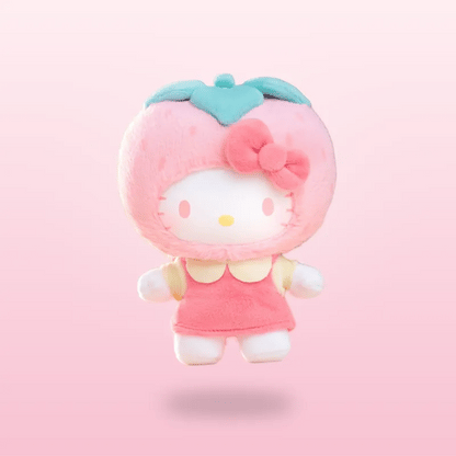 A Hello Kitty strawberry plush toy floating against a soft pink gradient background. The character is styled as a strawberry with a pink fuzzy body, a light blue-green leafy crown, a pink bow, and a pink dress.